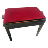 Piano bench, upholstered in red velvet.