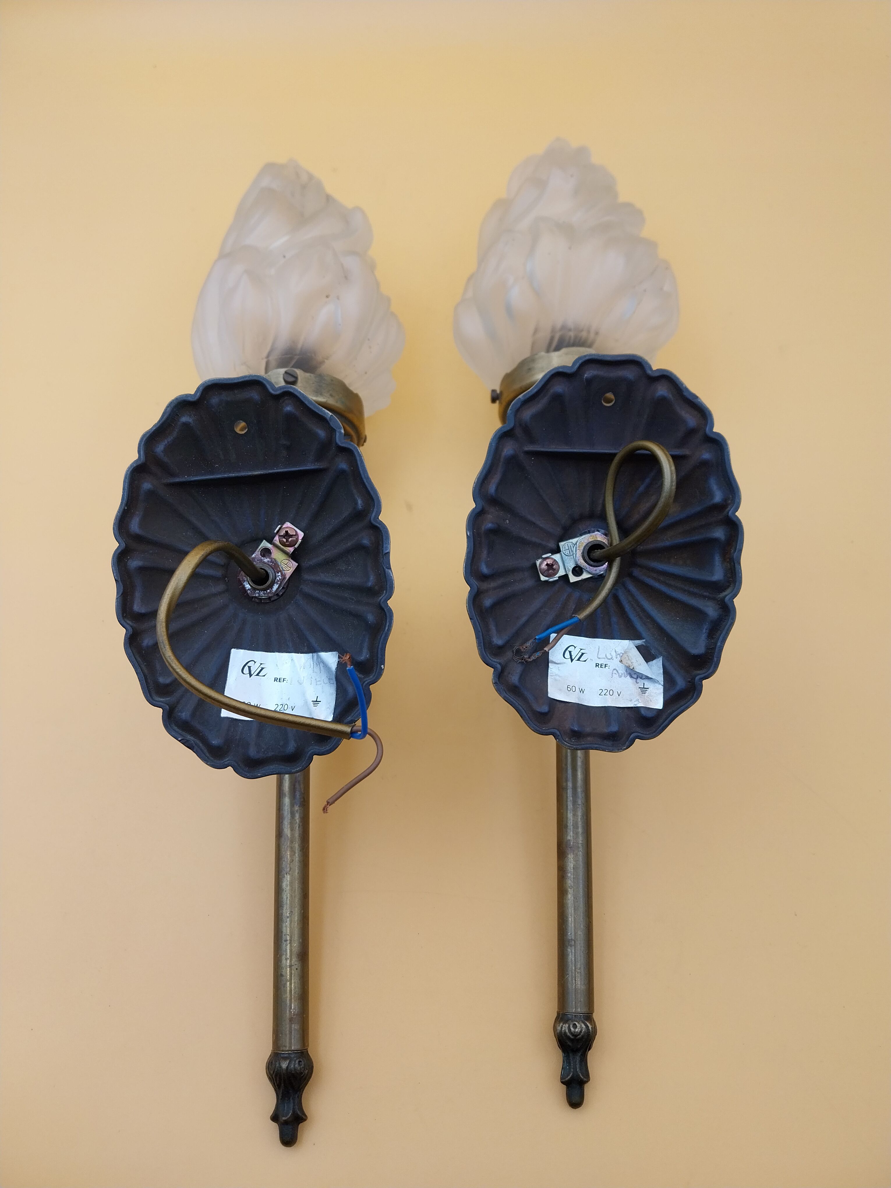 Pair of brass torch wall lights with globe flame.