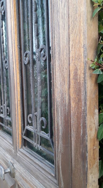Oak entrance door and its frame and transom, wrought iron gates