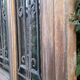 Oak entrance door and its frame and transom, wrought iron gates