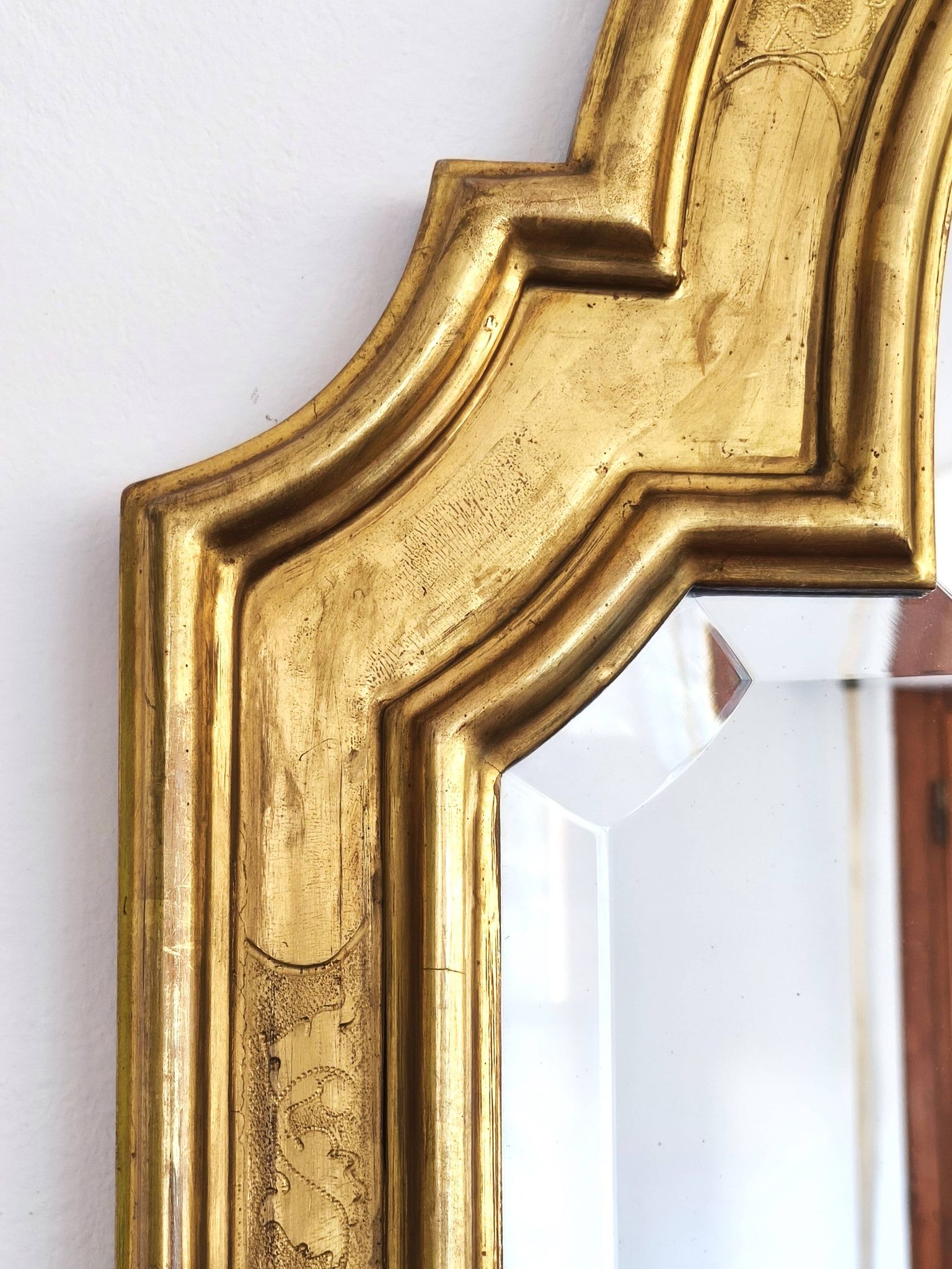 Florentine arched mirror in gilded wood with gold leaf.