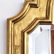 Florentine arched mirror in gilded wood with gold leaf.