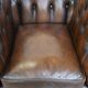 Cowhide English Chesterfield armchair with ball legs and timeless finish
