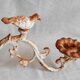 Wall lamp in antique cast iron with bird and scroll decorations.