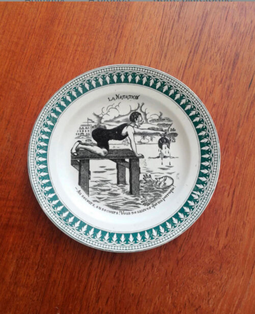 Old vintage dessert plate with drawing and phrase "swimming"