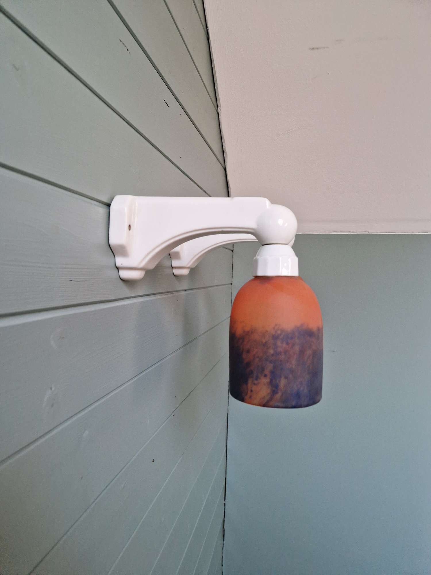 Pair of Art Deco wall sconces in multicoloured porcelain and frosted glass.