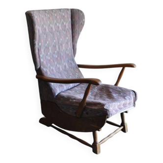 Vintage brown wooden rocking chair from the 1950s, wingback backrest and rocking base.