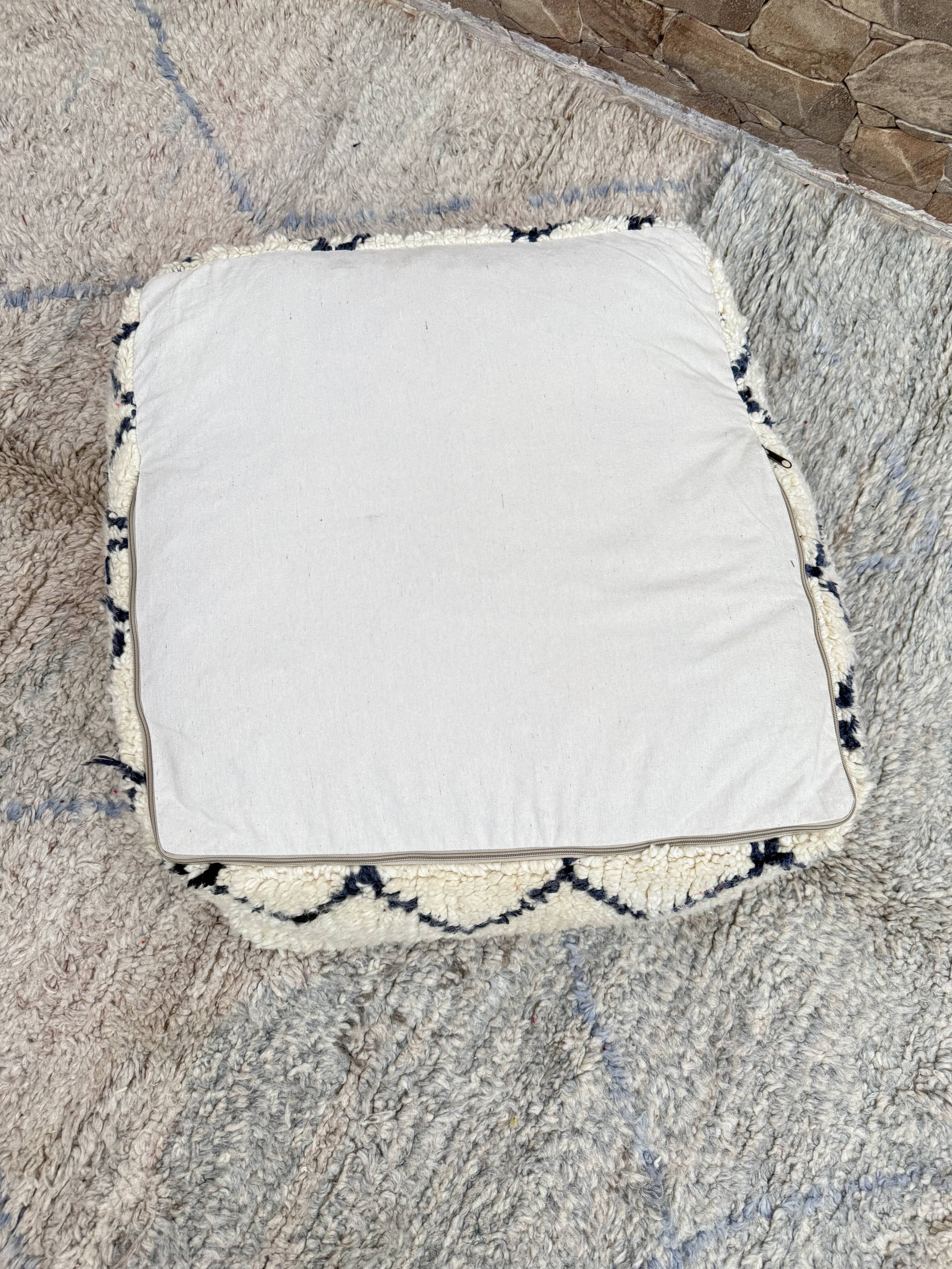 Berber floor pouf: Handwoven Moroccan wool cushion.