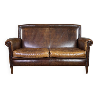 Beautiful dark cognac-colored cowhide 2-seater sofa in classic English style