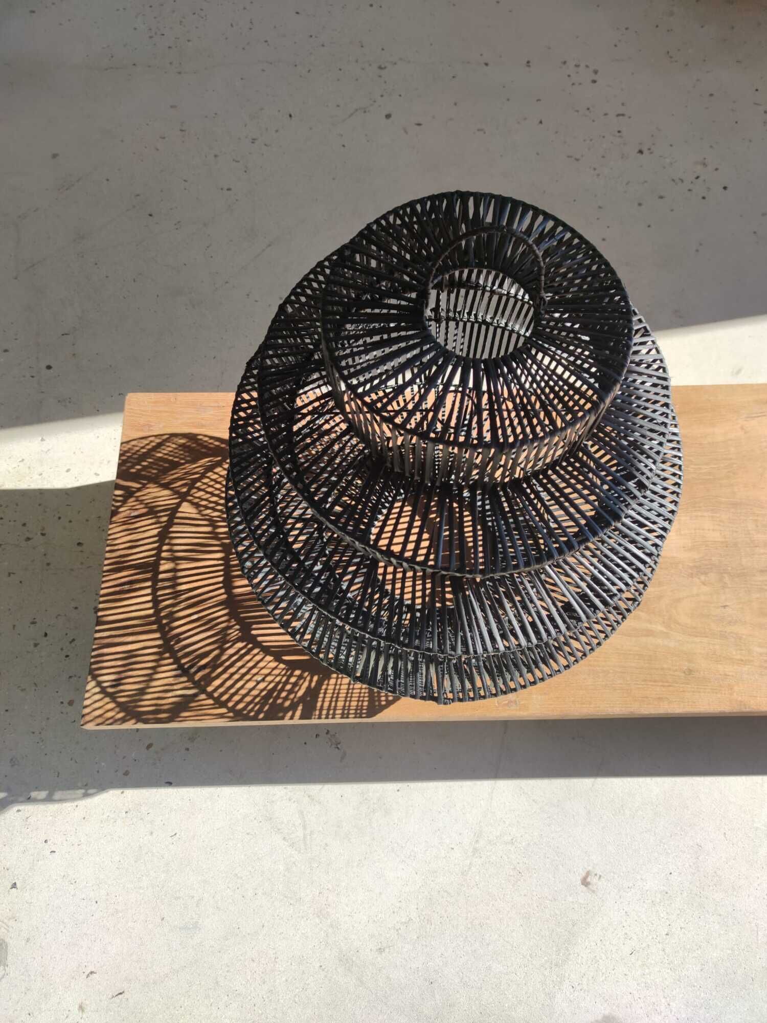 Braided rattan suspension in the shape of a black accordion