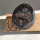 Braided rattan suspension in the shape of a black accordion