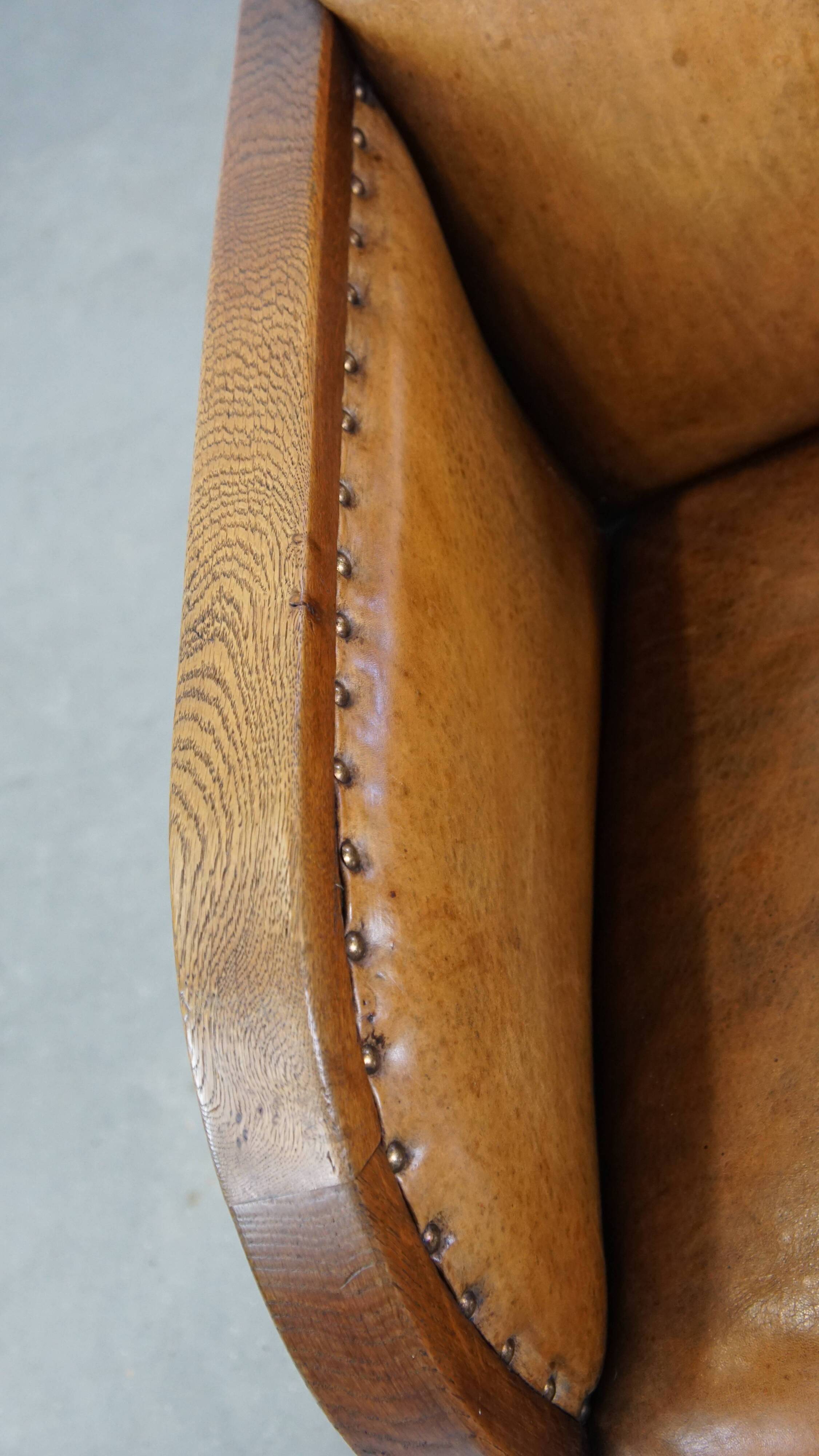 Cognac-colored sheepskin and wooden Art Deco design armchair