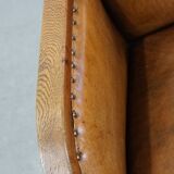 Cognac-colored sheepskin and wooden Art Deco design armchair