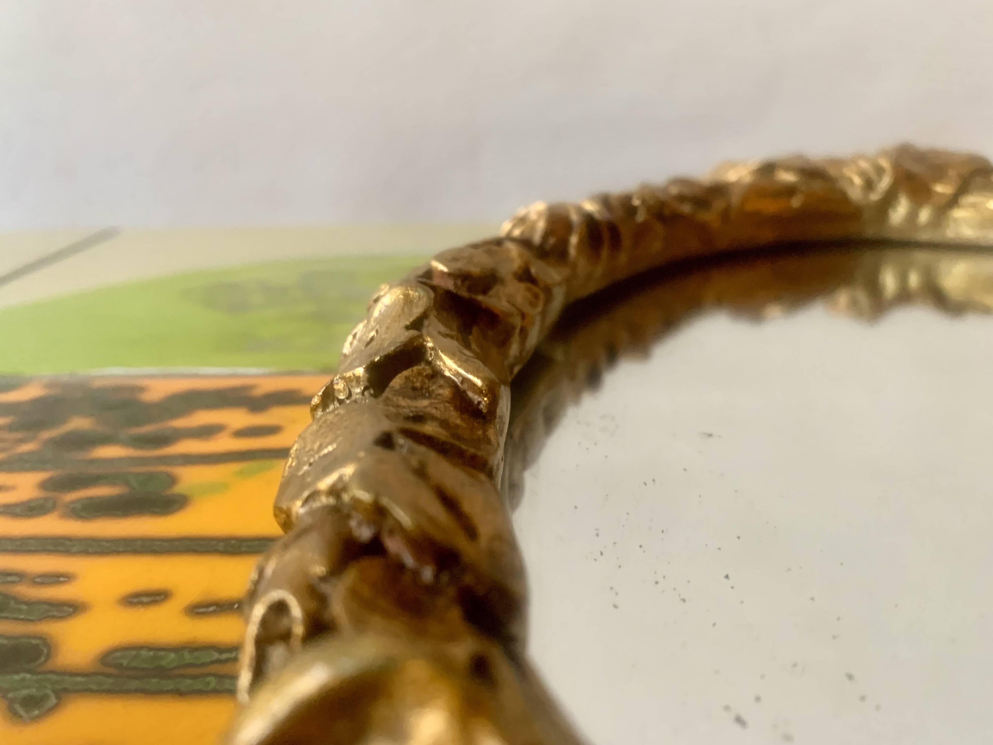 Small vintage oval wall mirror in varnished gold resin