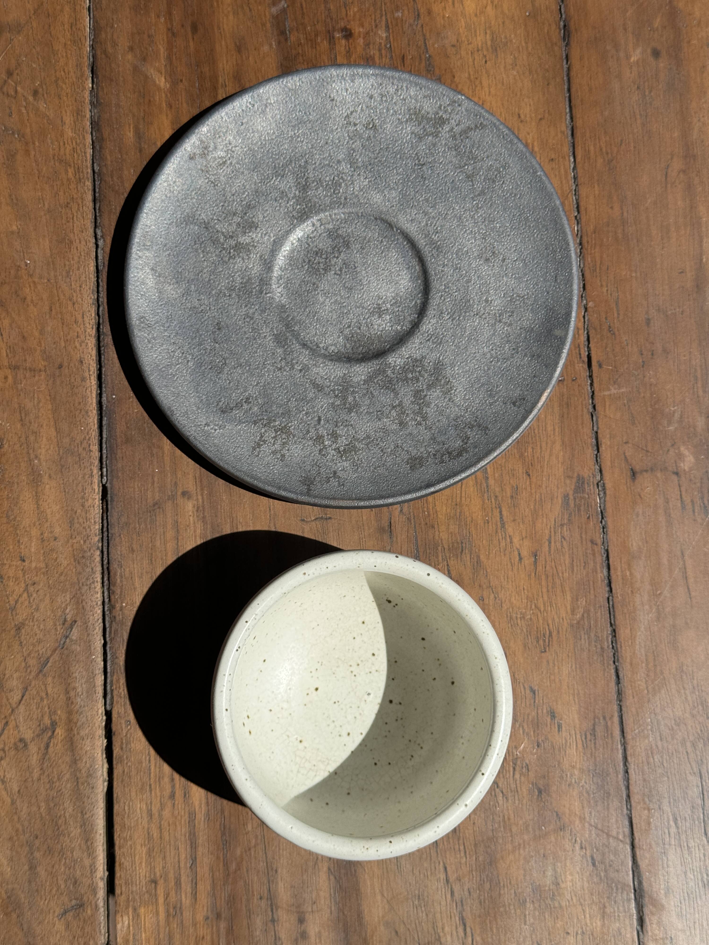 White Indonesian ceramic cup and gray saucer
