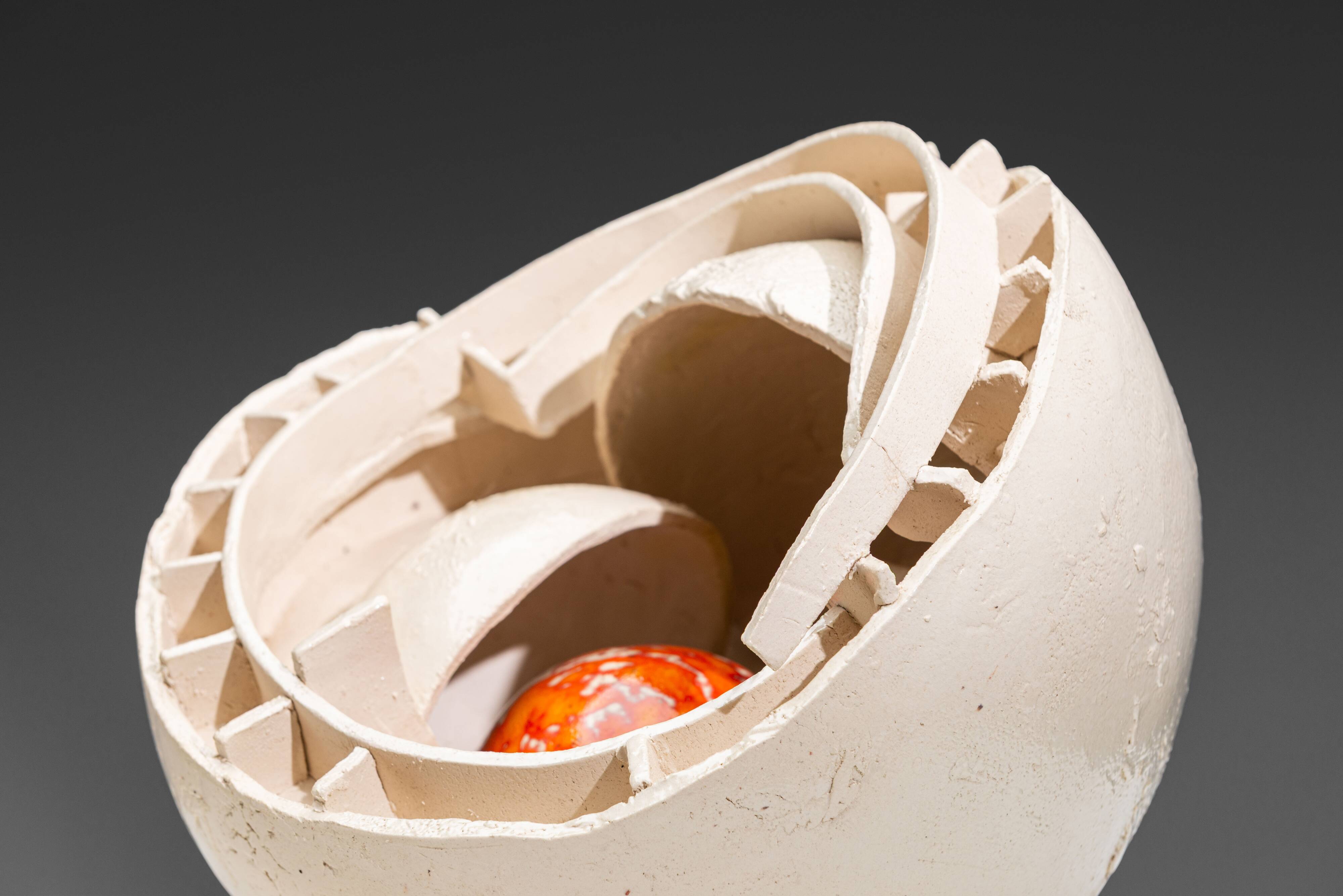 Sculpture en céramique abstraite avec un noyau orange.