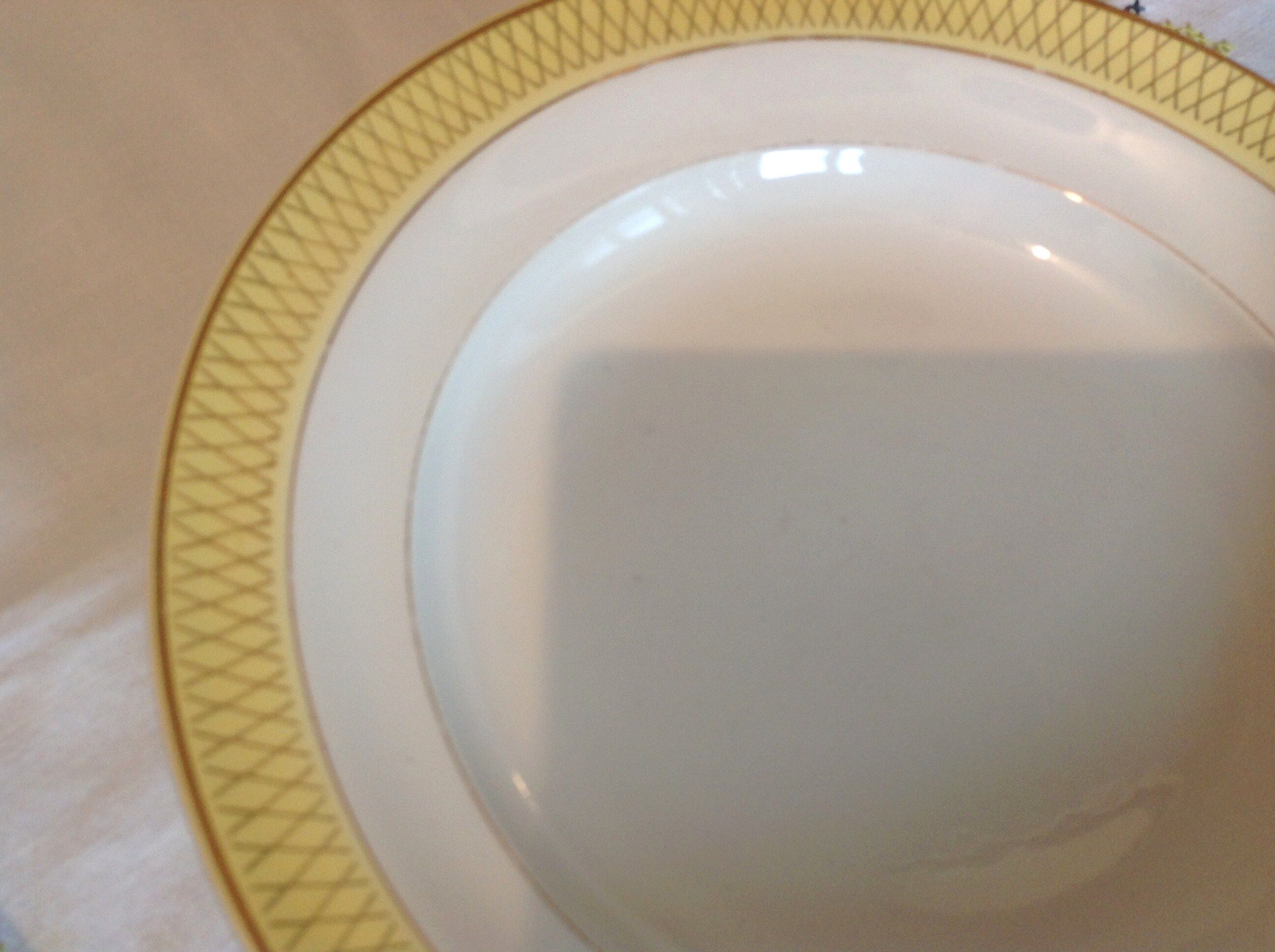 Six white hollow plates on board yellow Monaco 60