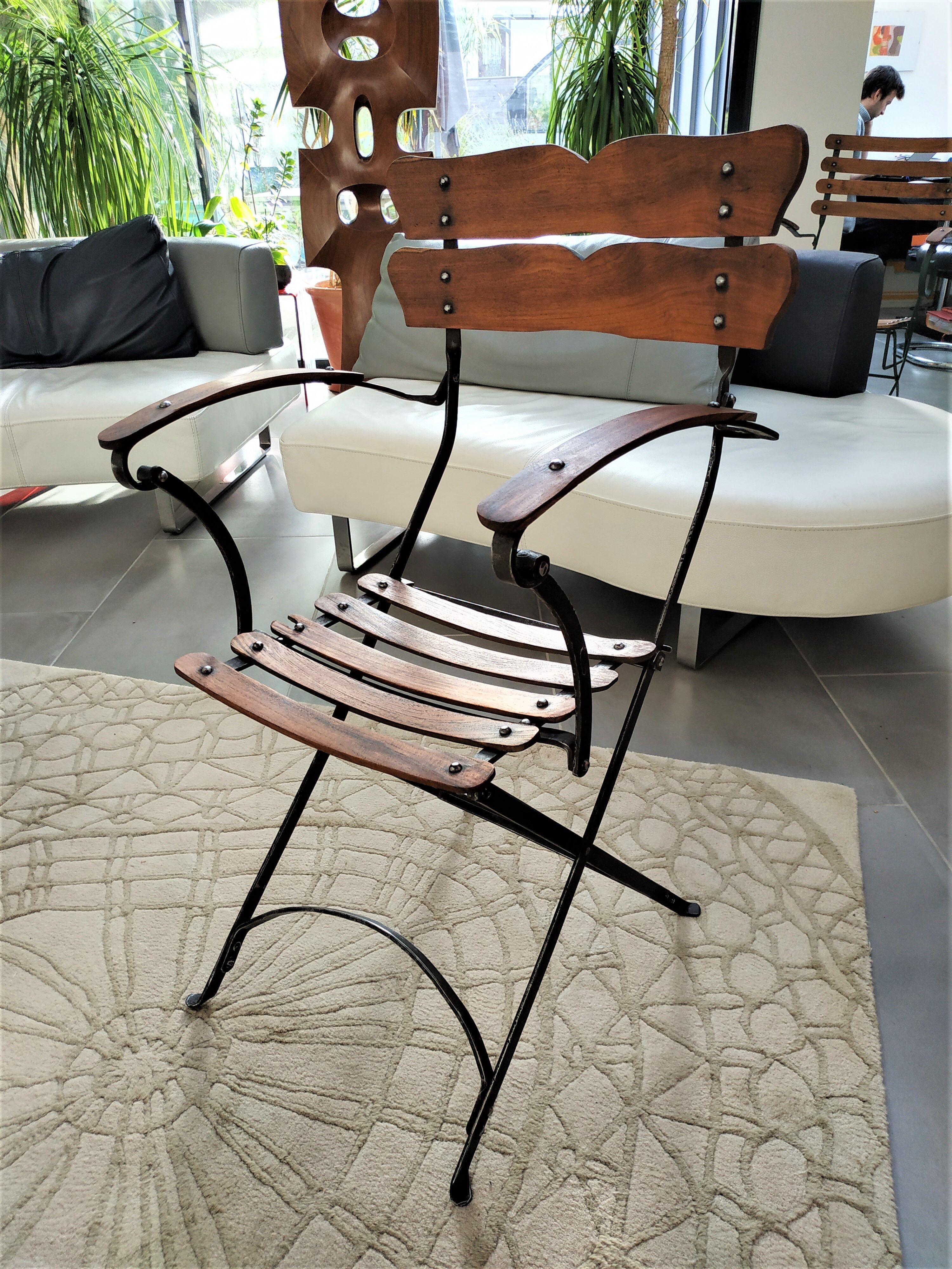 Folding garden chair with teak slats on a wrought iron structure