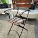 Folding garden chair with teak slats on a wrought iron structure