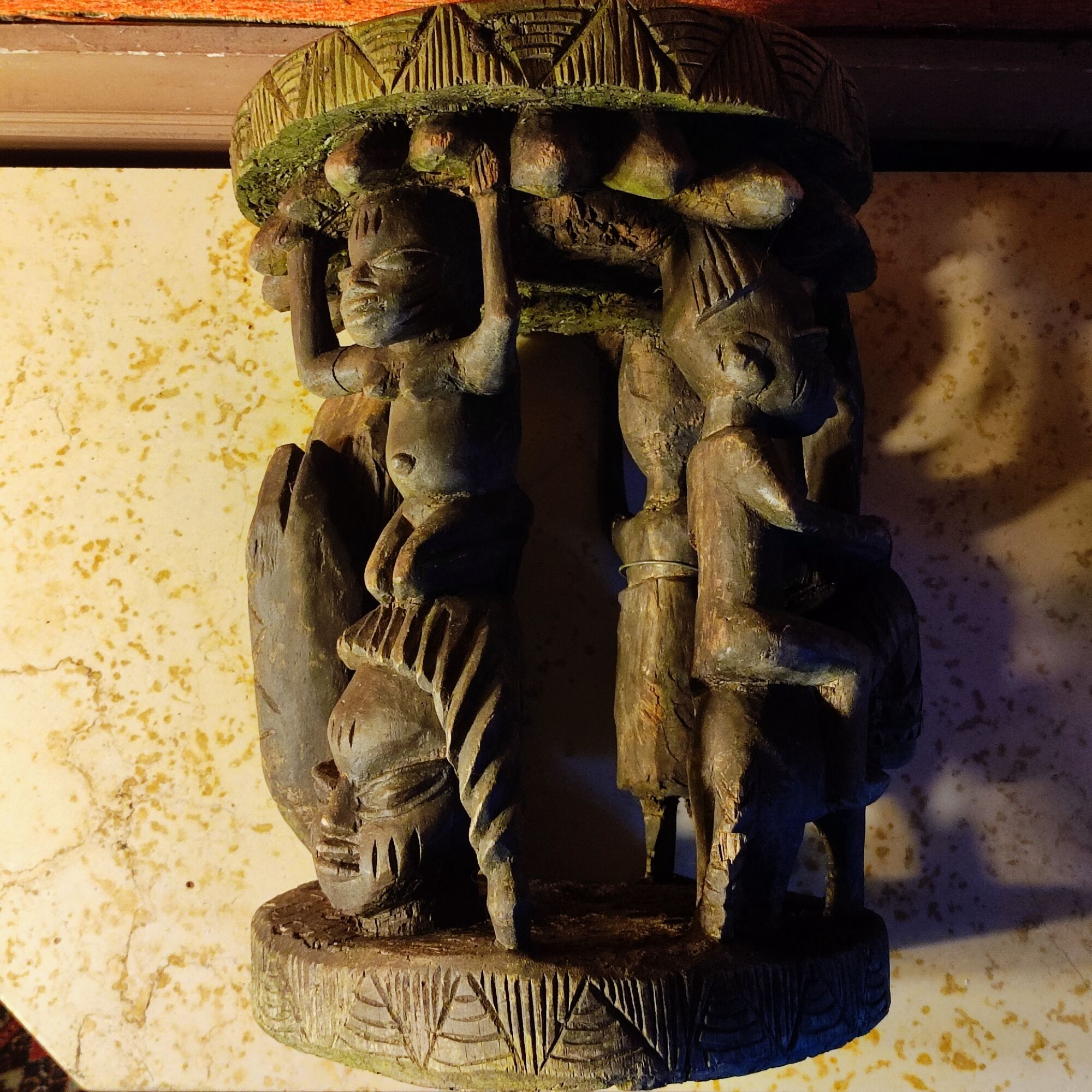 African wooden stool carved in the shapes of characters