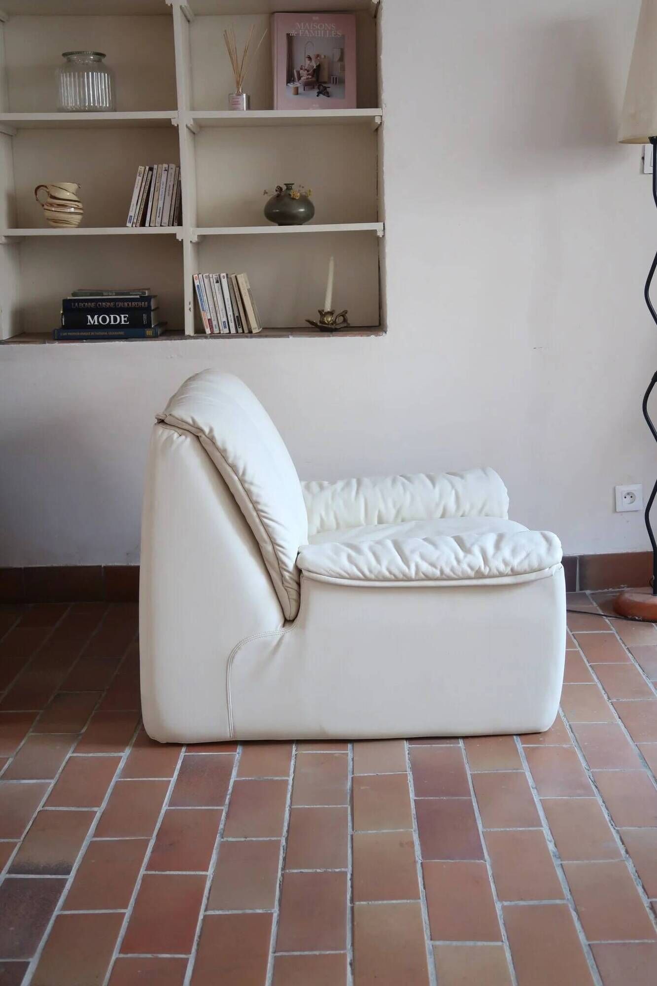 Cinna armchair in cream leather, bolstered armrests, 1970s.