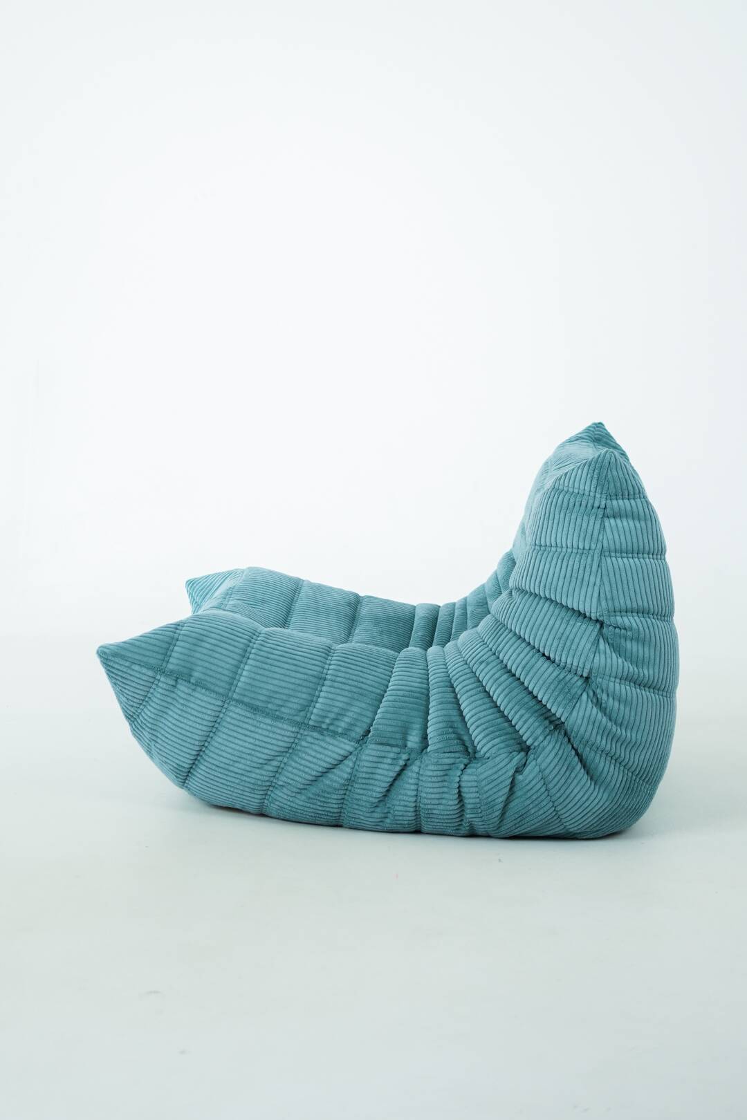 Ensemble de fauteuil et pouf Togo en velours côtelé bleu clair.