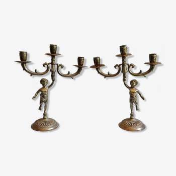 Pair of three-armed cherub-shaped bronze candle holders