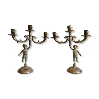 Pair of three-armed cherub-shaped bronze candle holders