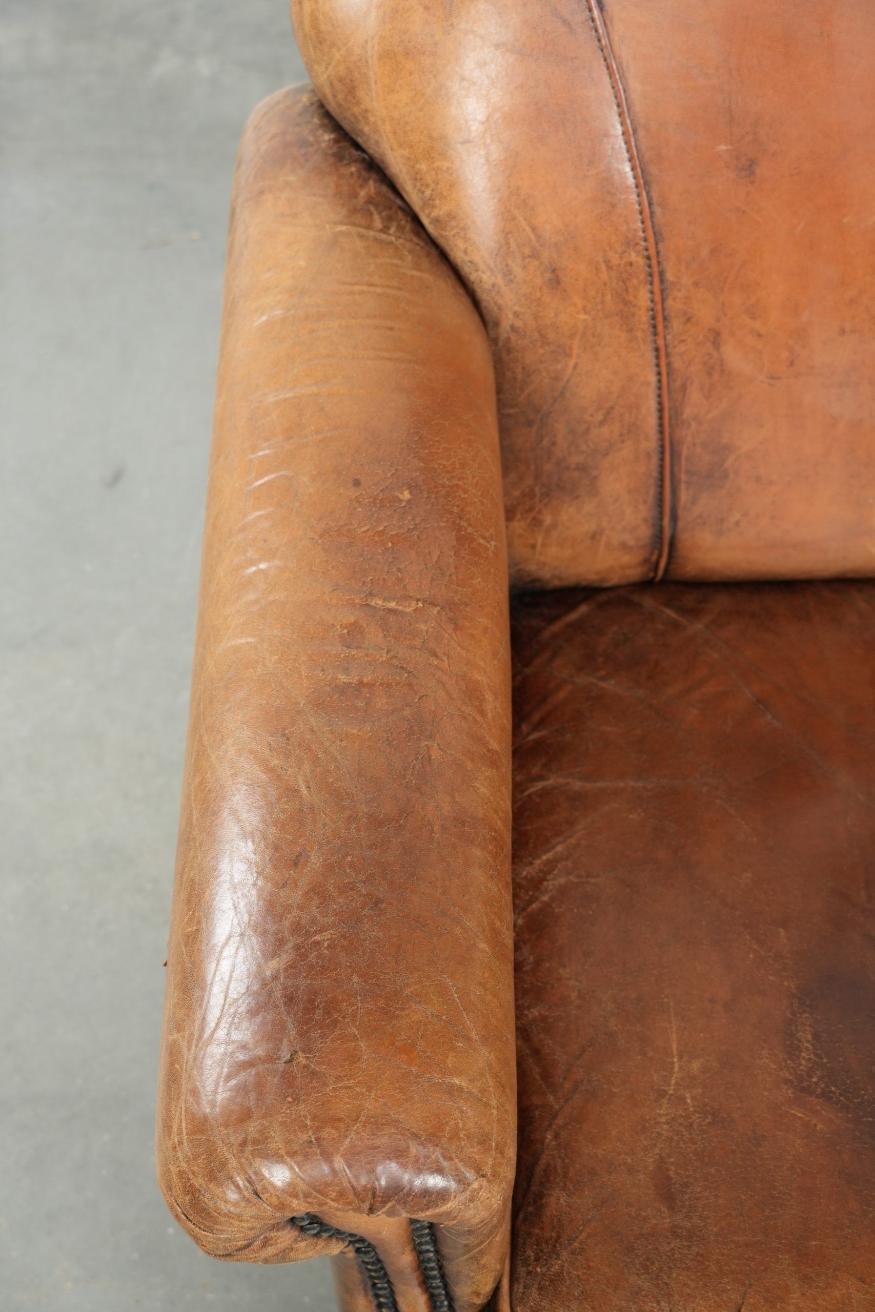 Sheepskin armchair with a beautiful vintage look and decorative nail finish