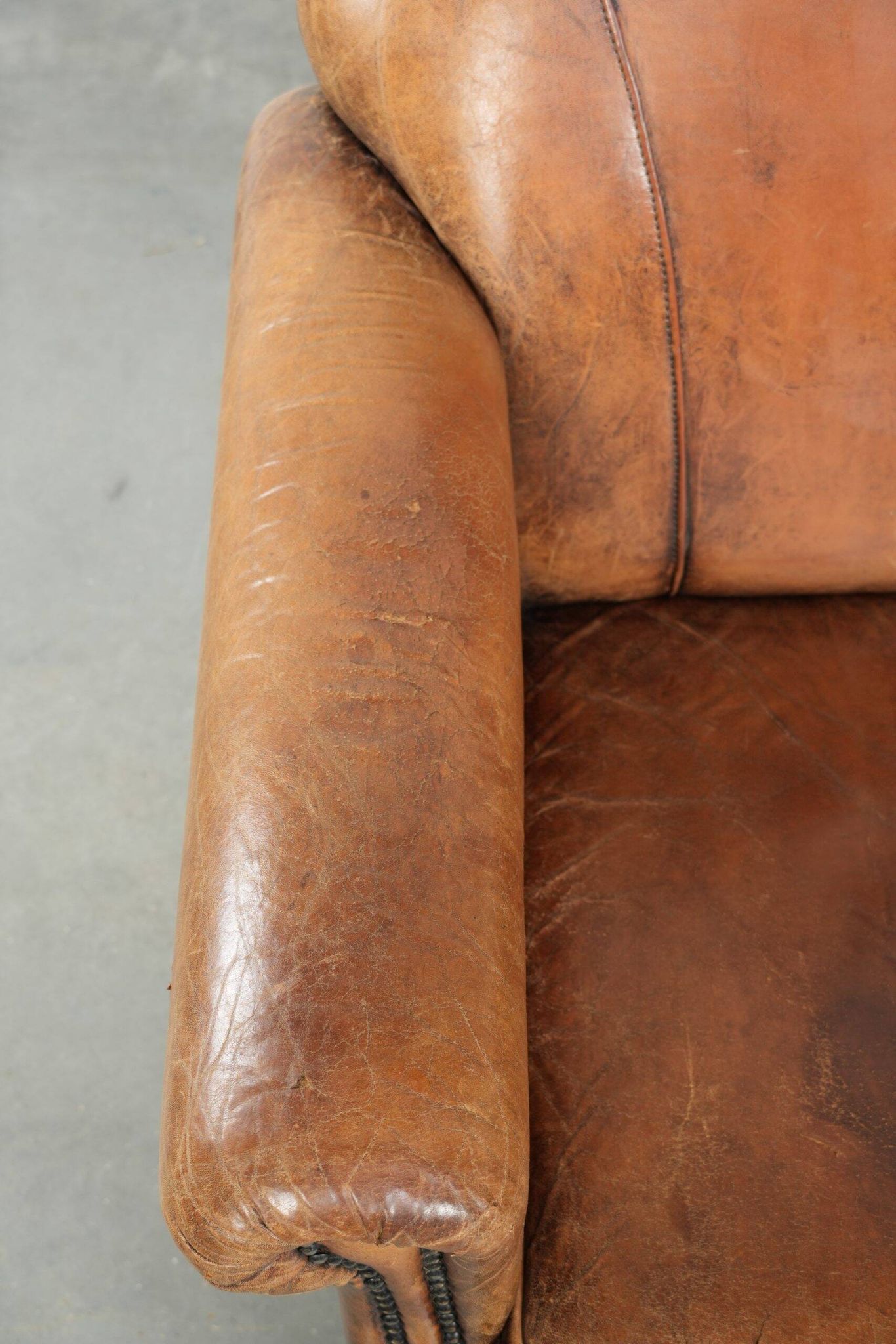 Sheepskin armchair with a beautiful vintage look and decorative nail finish