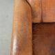 Sheepskin armchair with a beautiful vintage look and decorative nail finish