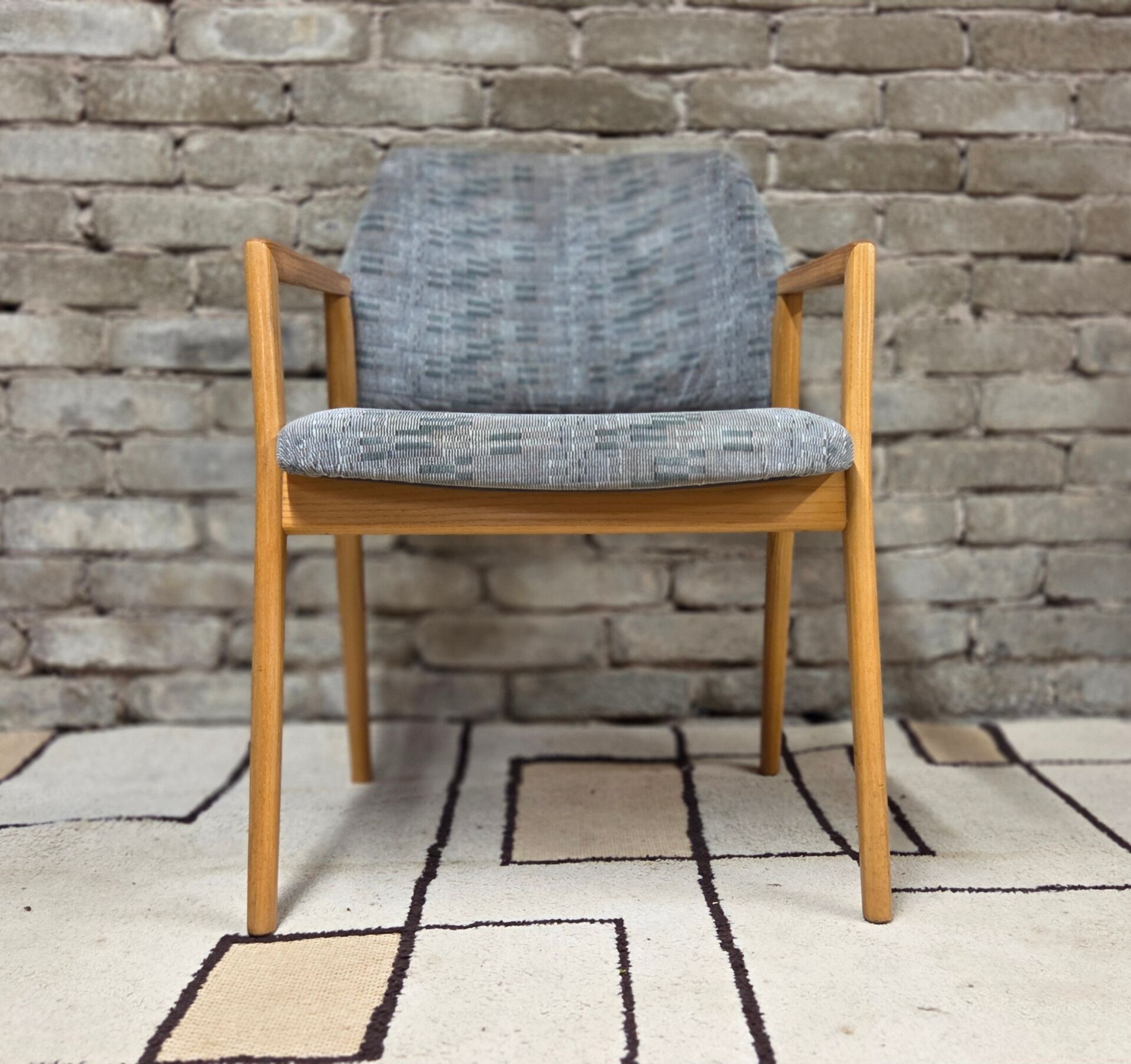 Vintage armchair from the 60s/70s in wood and grey fabric – with armrests.