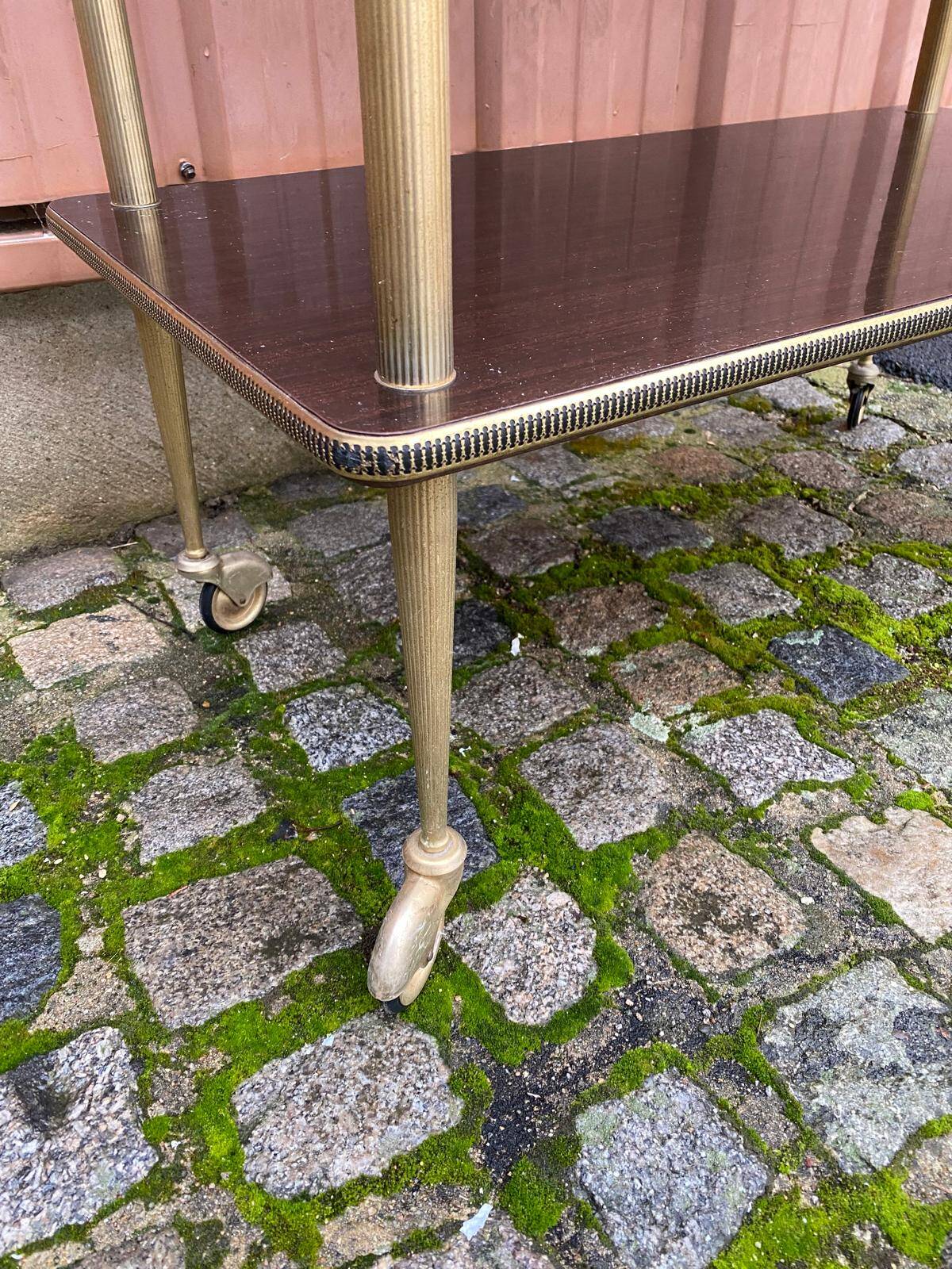 Brown rosewood rolling table with gold fluted legs