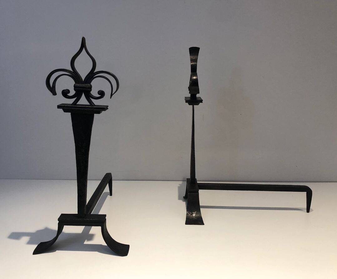 Important pair of wrought iron andirons with torch in heraldic fleur-de-lis design.