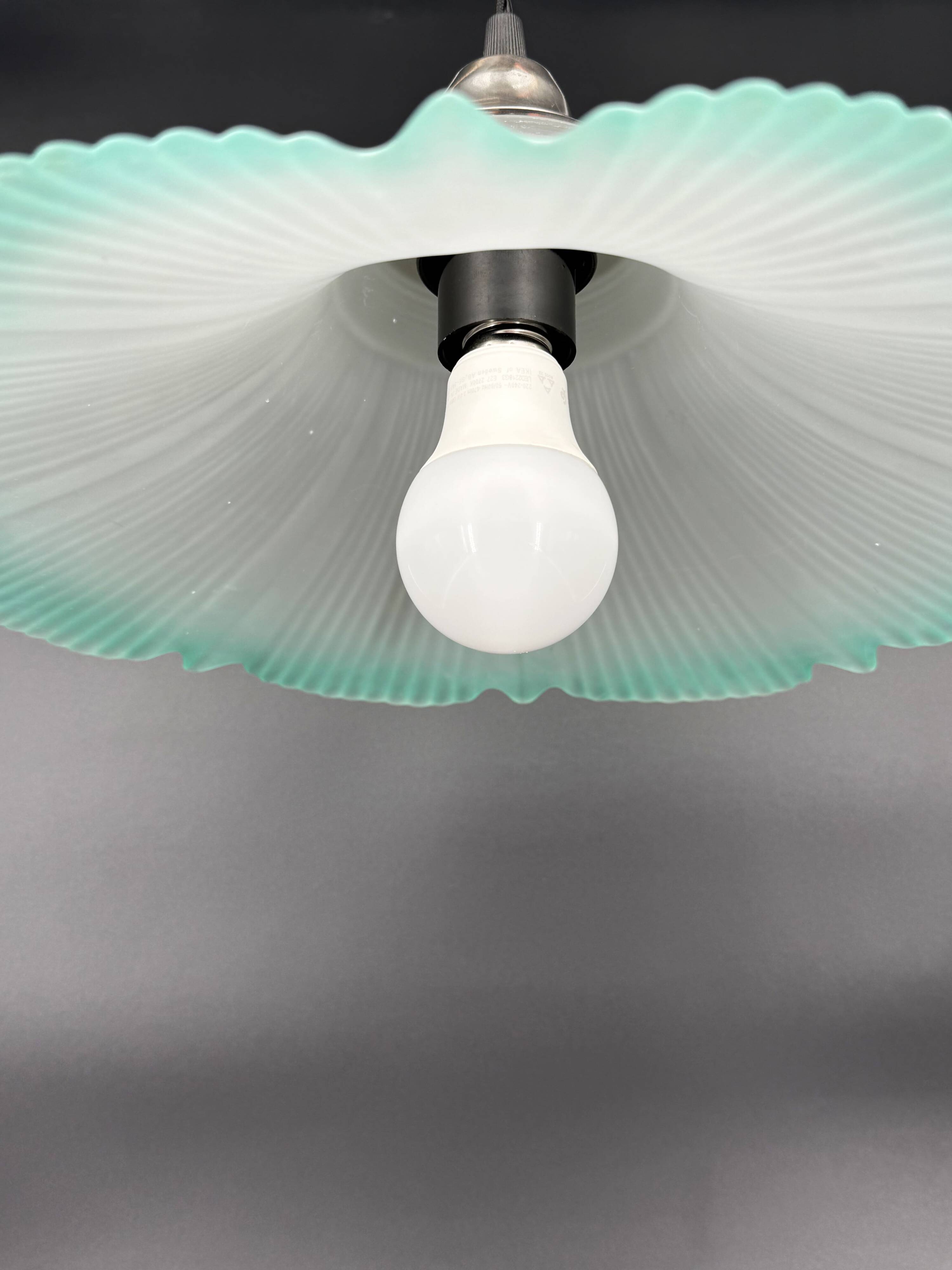 Frosted glass flower pendant with a water green edge.