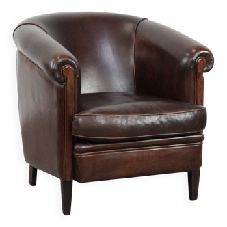 Dark brown vintage club armchair in English style made of sheepskin leather