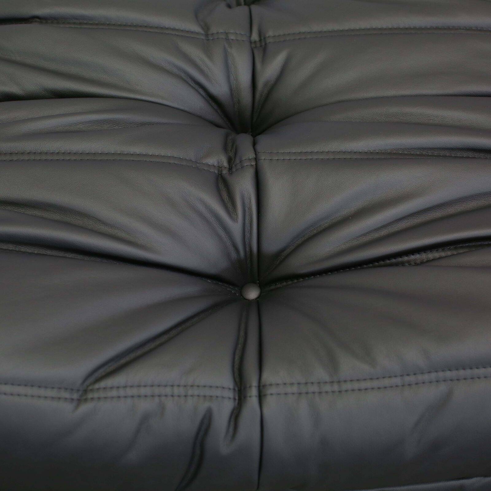 Togo armchair and footrest in black leather by Ligne Roset, designed by Michel Ducaroy.