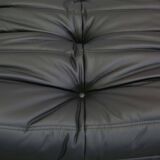 Togo armchair and footrest in black leather by Ligne Roset, designed by Michel Ducaroy.