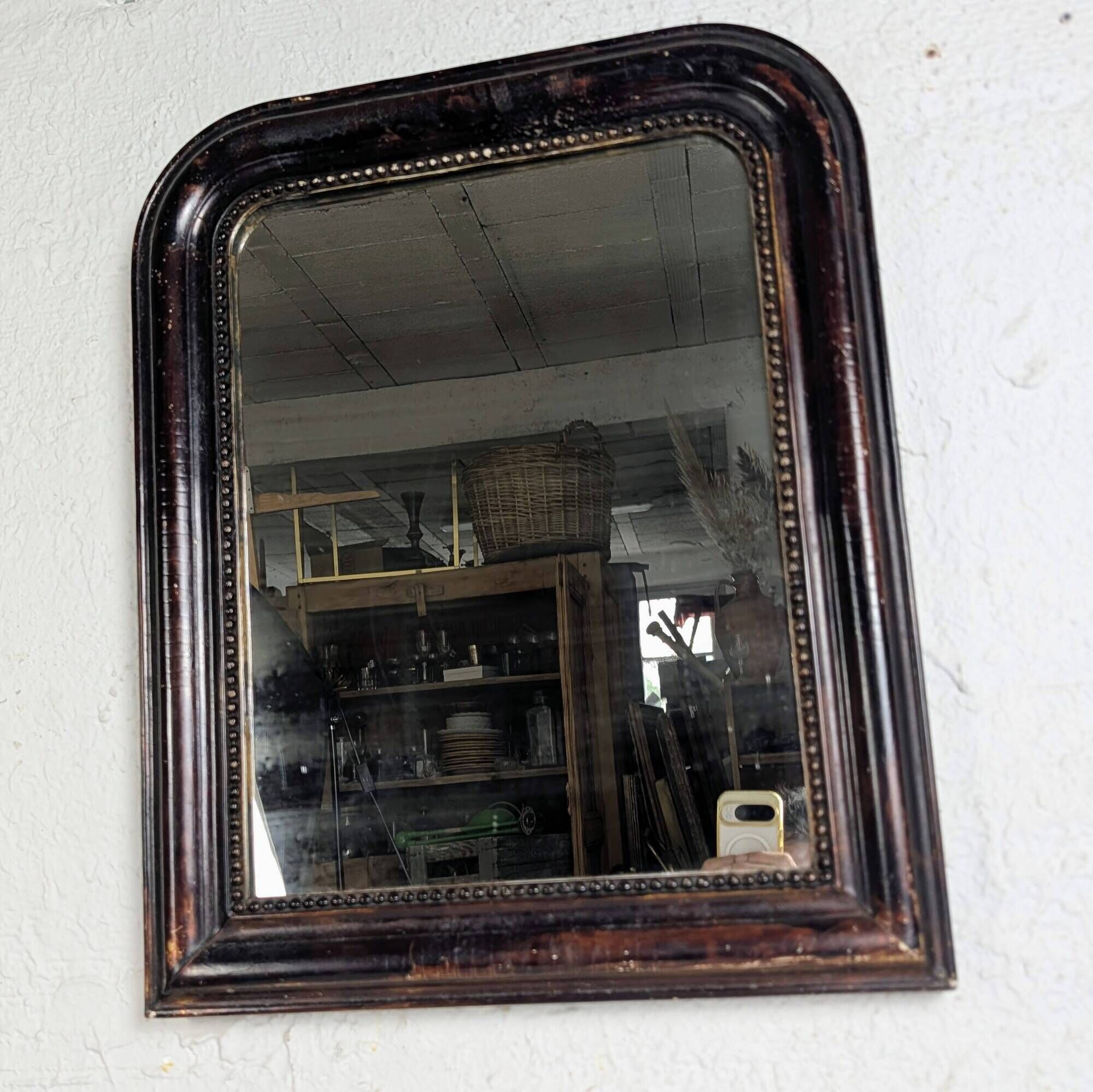 Antique Louis Philippe mirror with a patinated black frame.