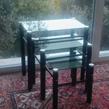 3 nesting tables in black metal with smoked glass tops.