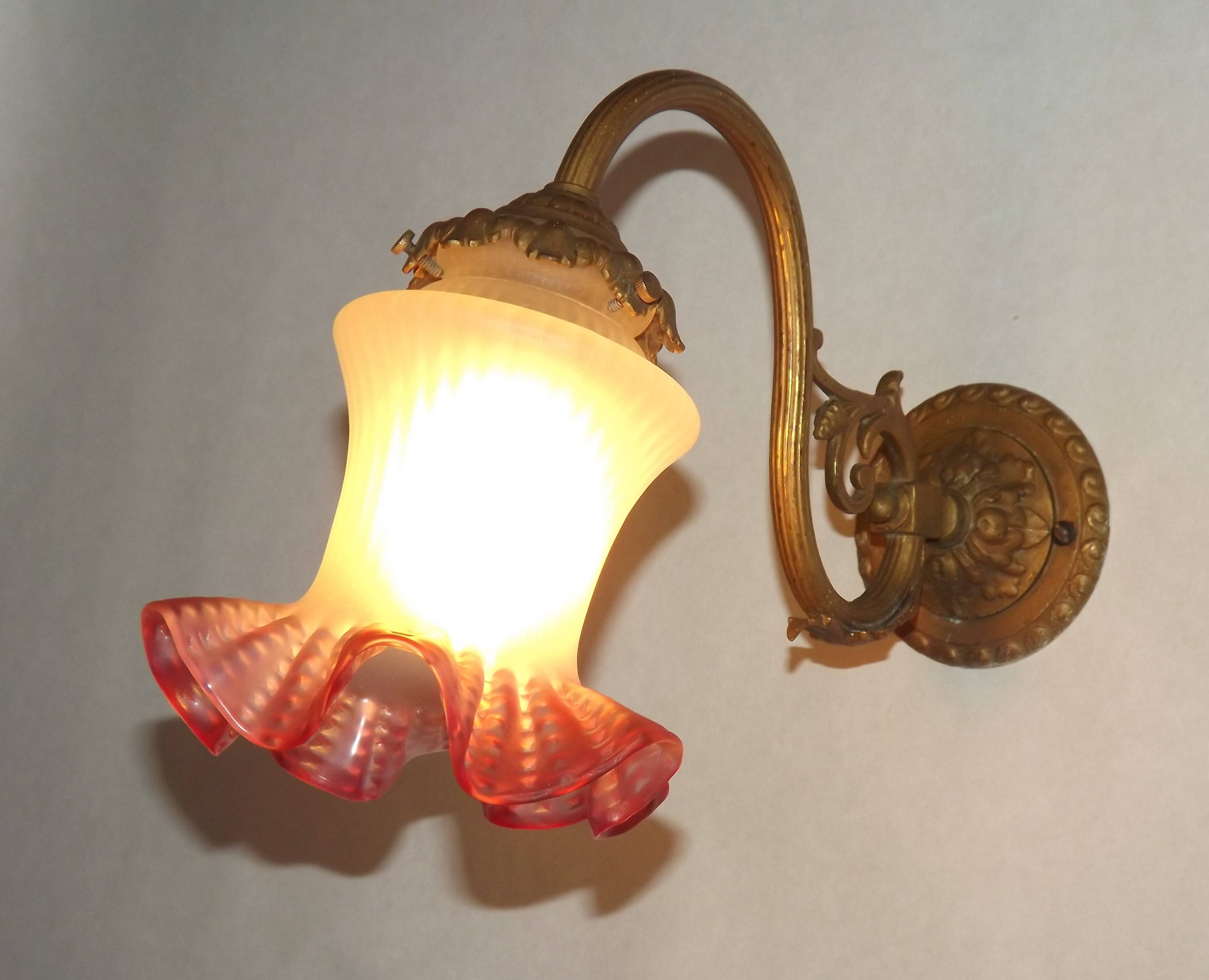 French Art Nouveau wall sconce in bronze with a white and pink glass shade.