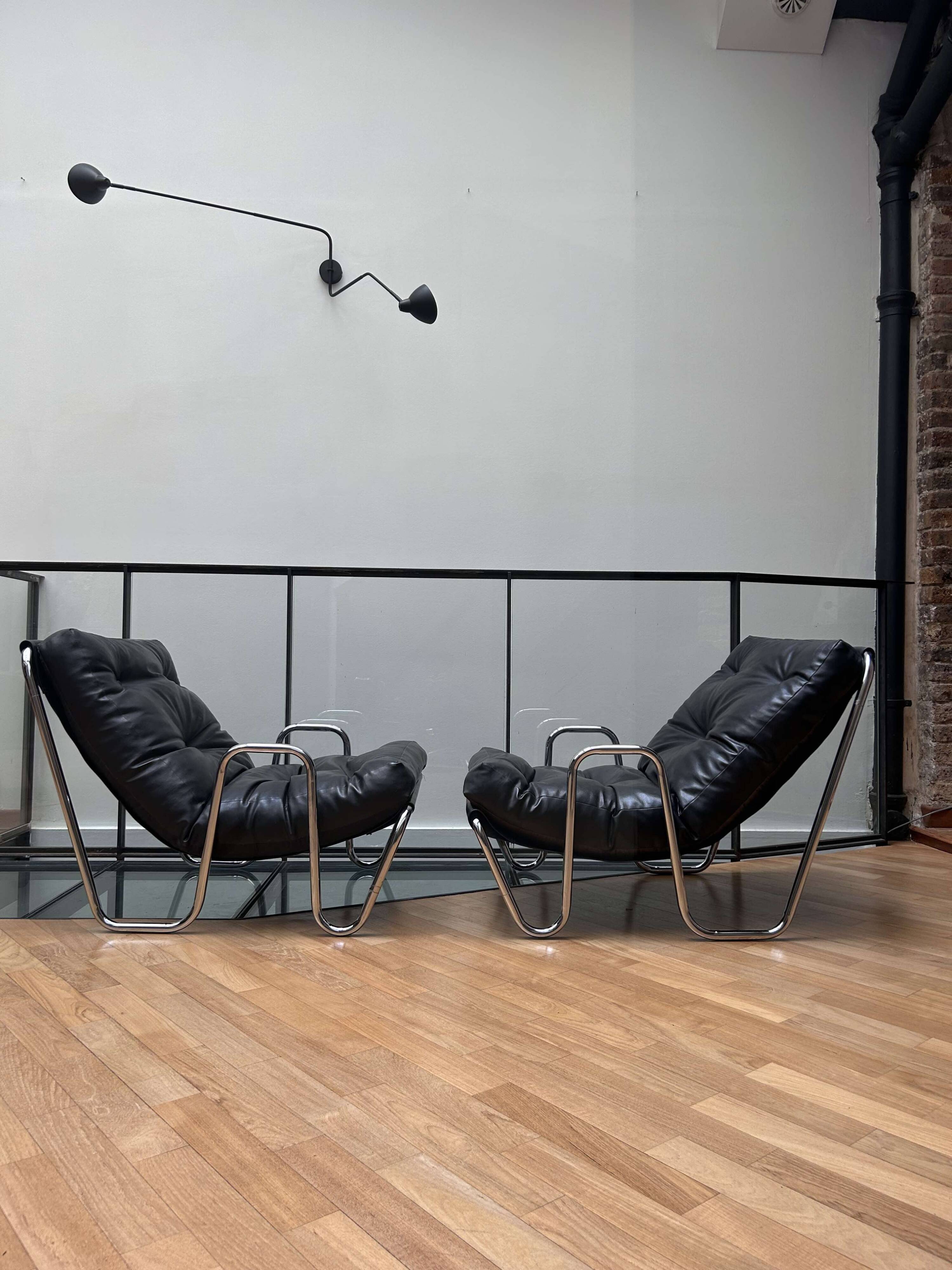 Pair of vintage armchairs in black imitation leather and chrome metal, France 1970