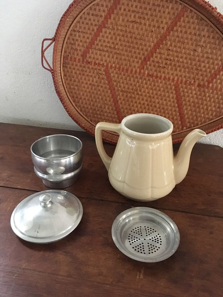 Old tea pot or coffee maker in faience cream with filter.