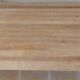 Large natural wood table with rectangular top supported by legs