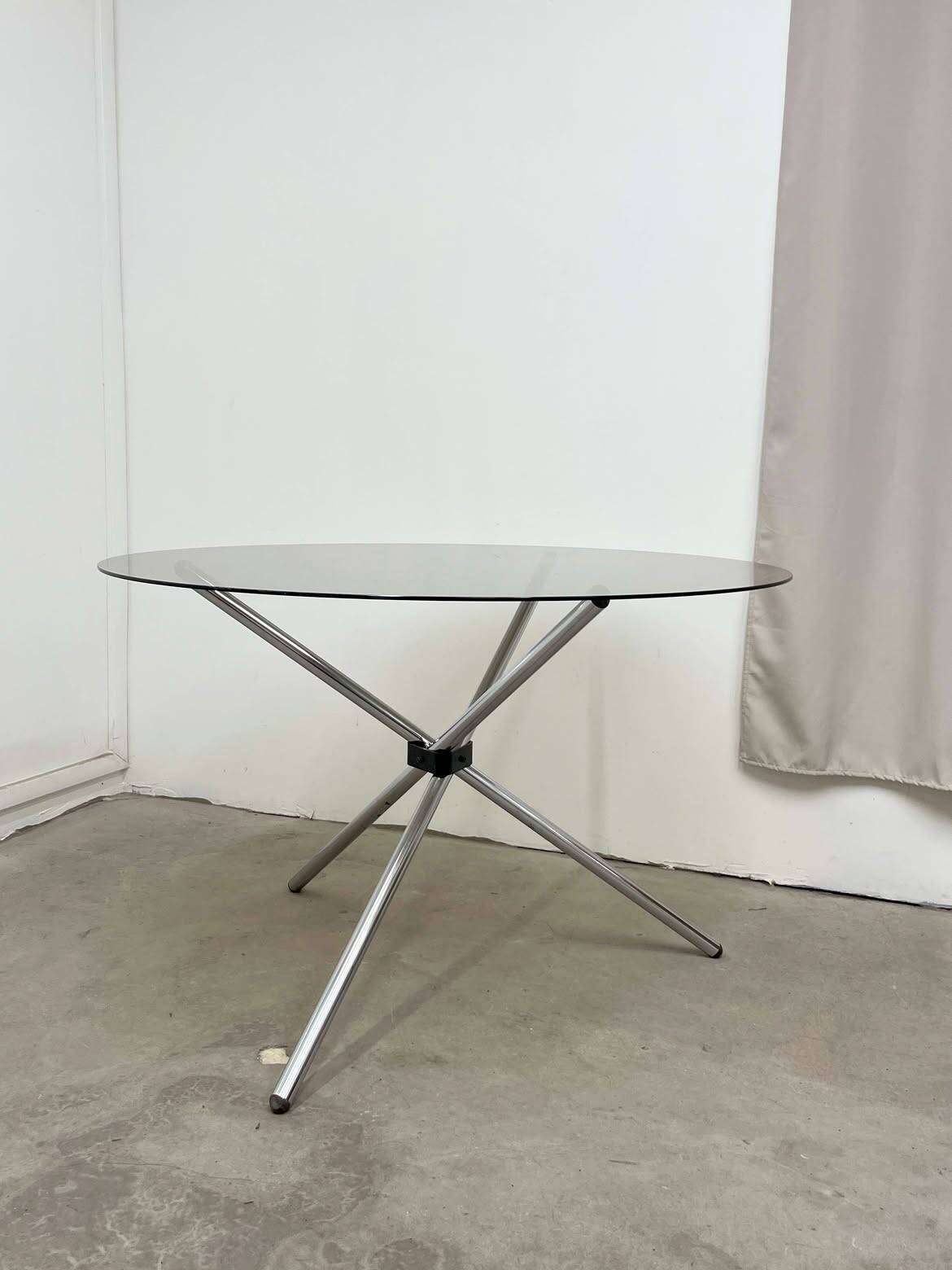 Round dining table in chrome and smoked glass.