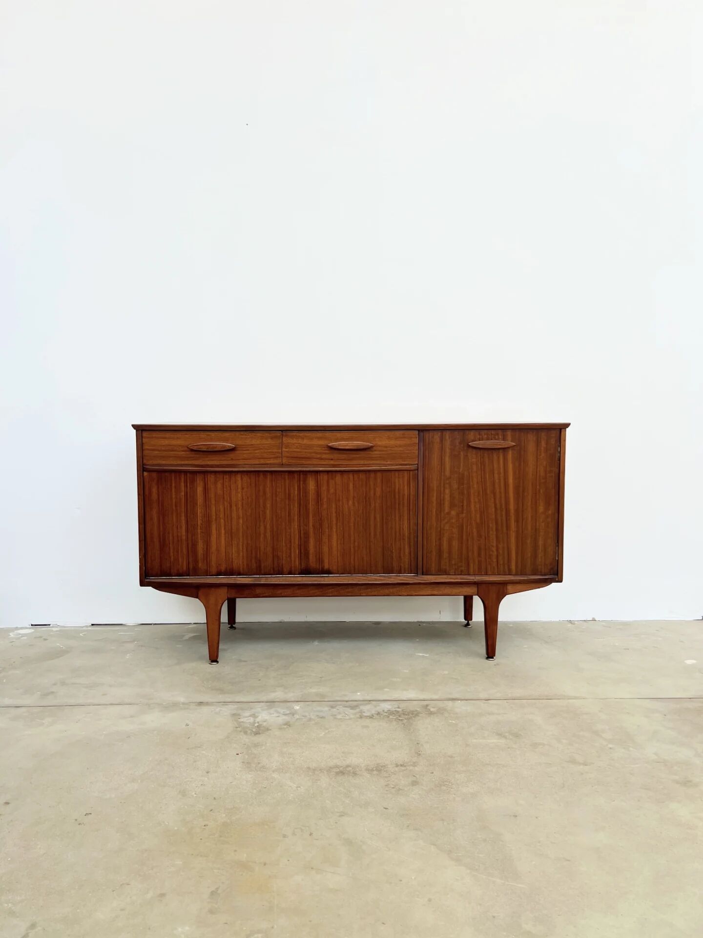 Teak Jentique sideboard — 1 door, 2 drawers & drop-down bar, England 1950s-60s
