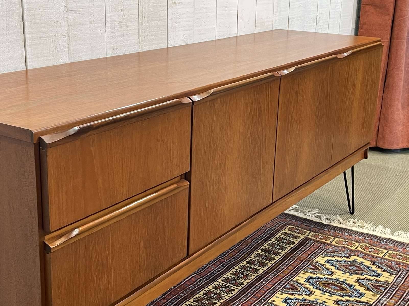 1970s English enfilade in teak with splayed legs.