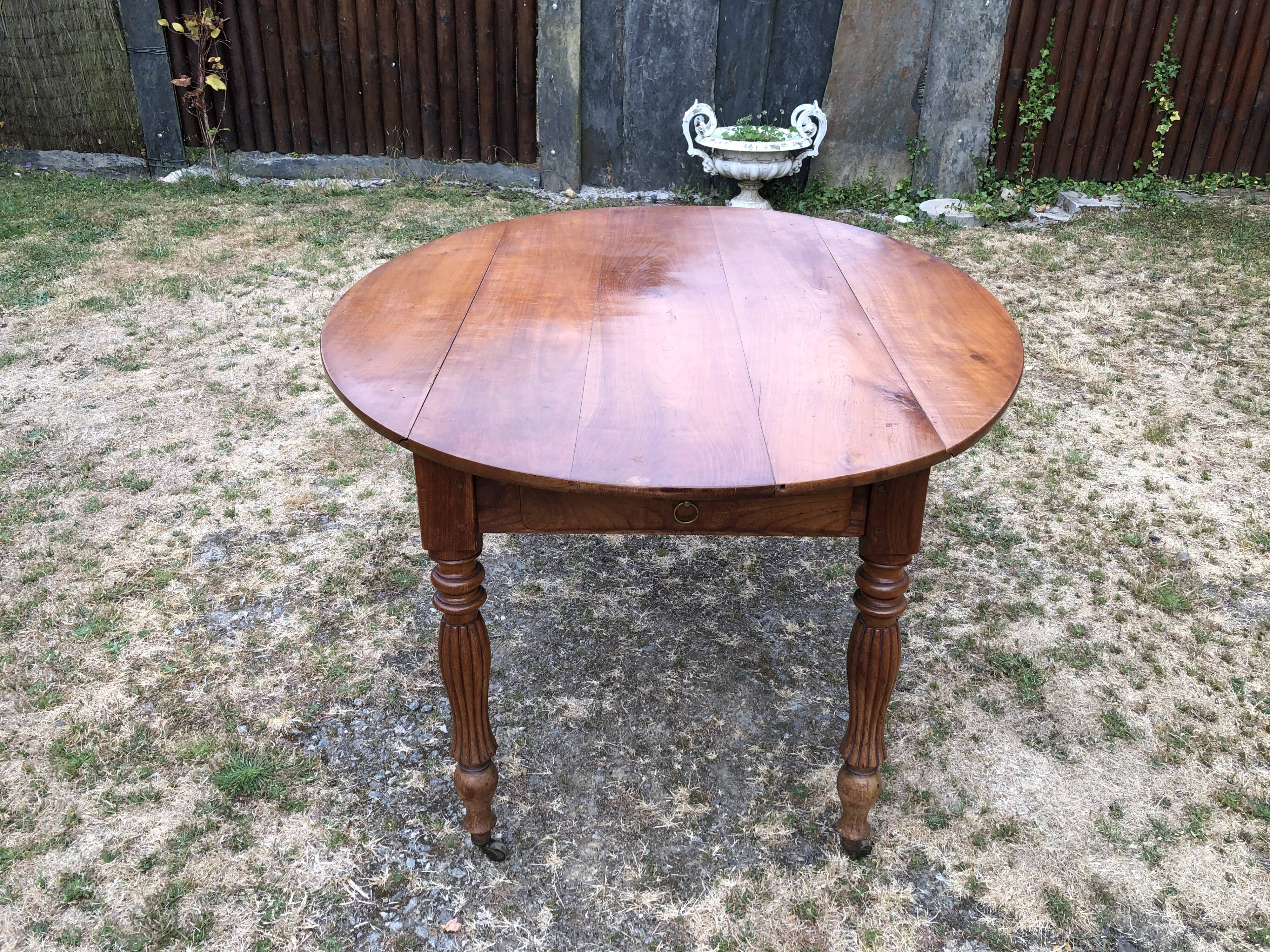 Louis Philippe oval drop-leaf table in solid cherry wood with 2 drawers.