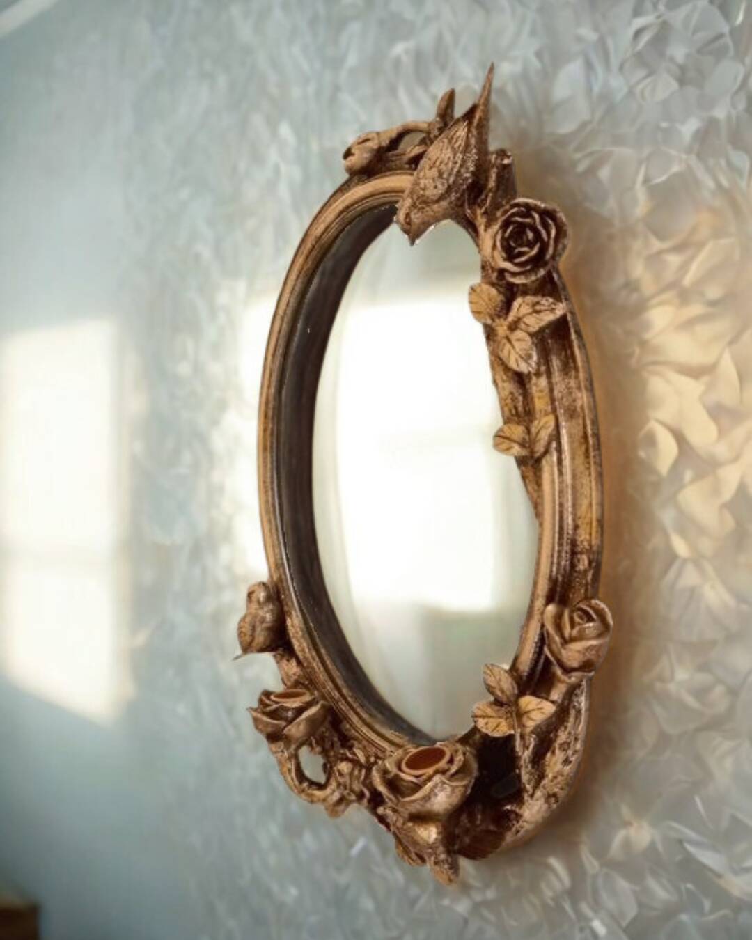 Oval wall mirror in Art Nouveau style with a decoration of birds and roses.