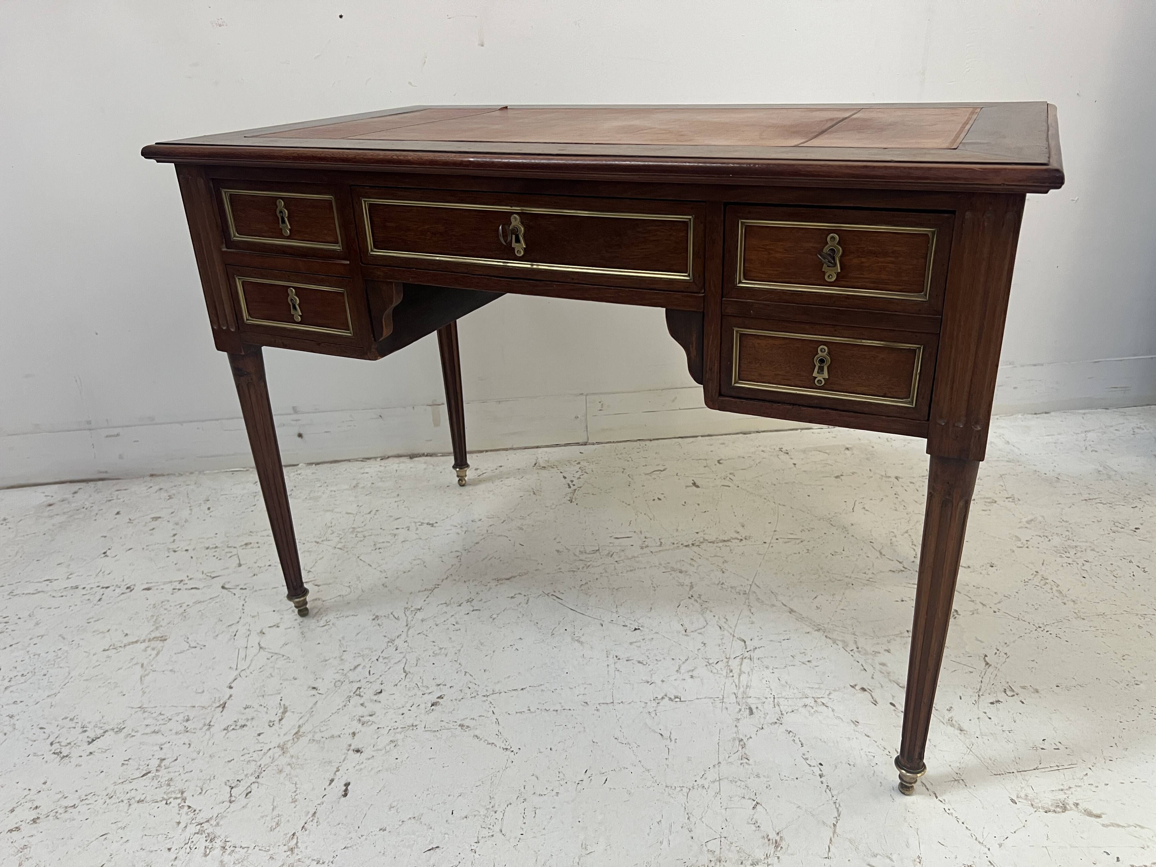 Louis XVI style desk in mahogany and mahogany veneer, 20th century.